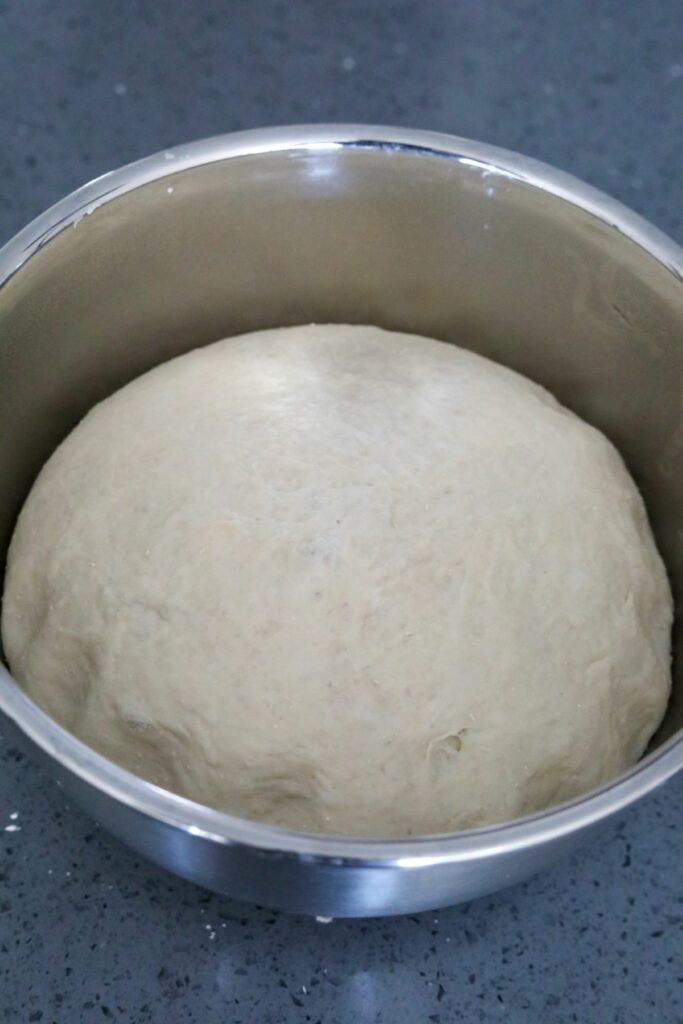 Dough ball doubled in size in a bowl