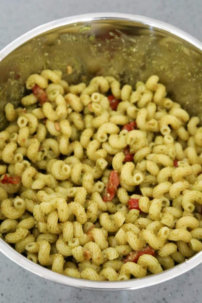 Mixed pesto pasta in a mixing bowl