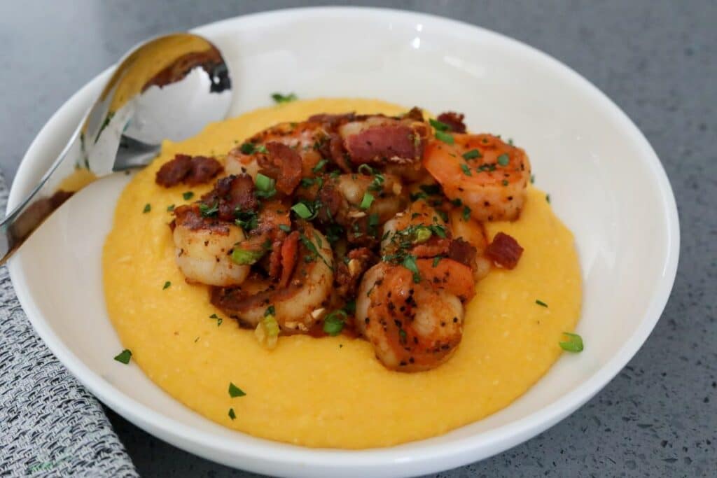 A bowl of shrimp and grits with a spoon