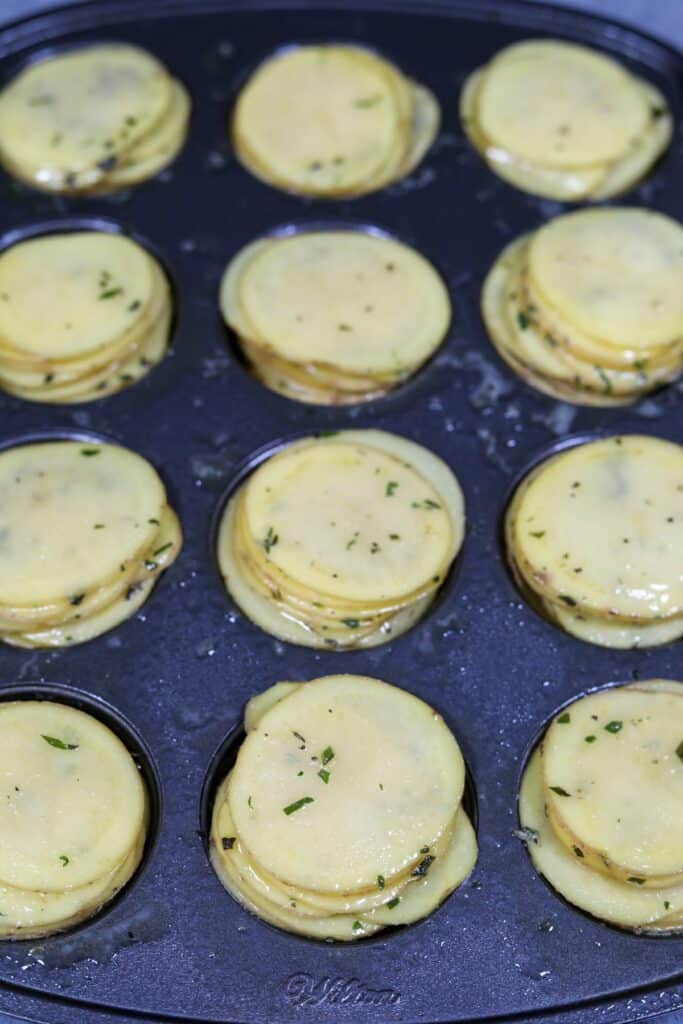Uncooked potato slices in a muffin tin
