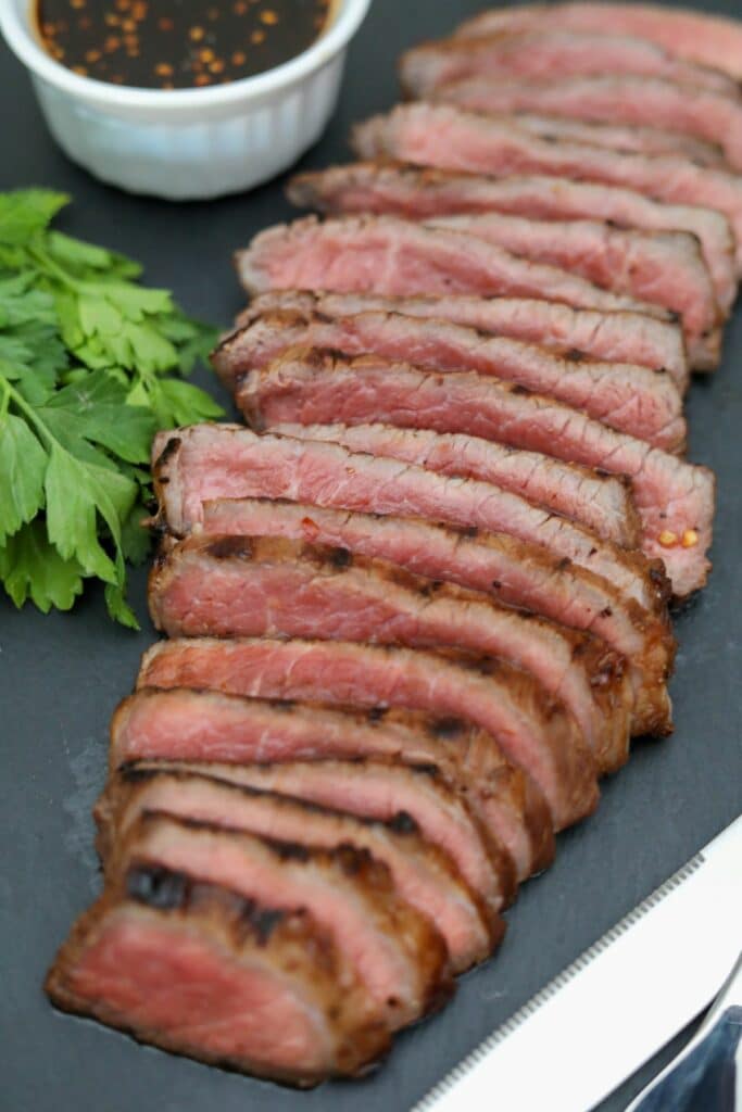 Sliced grilled London broil on a slate plate