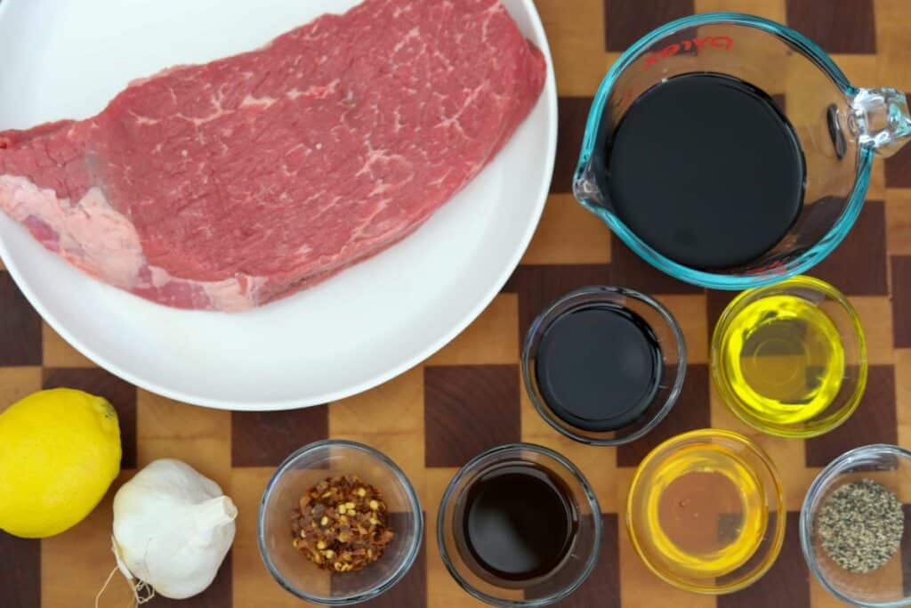 Ingredients for grilled London broil on a wooden cutting board