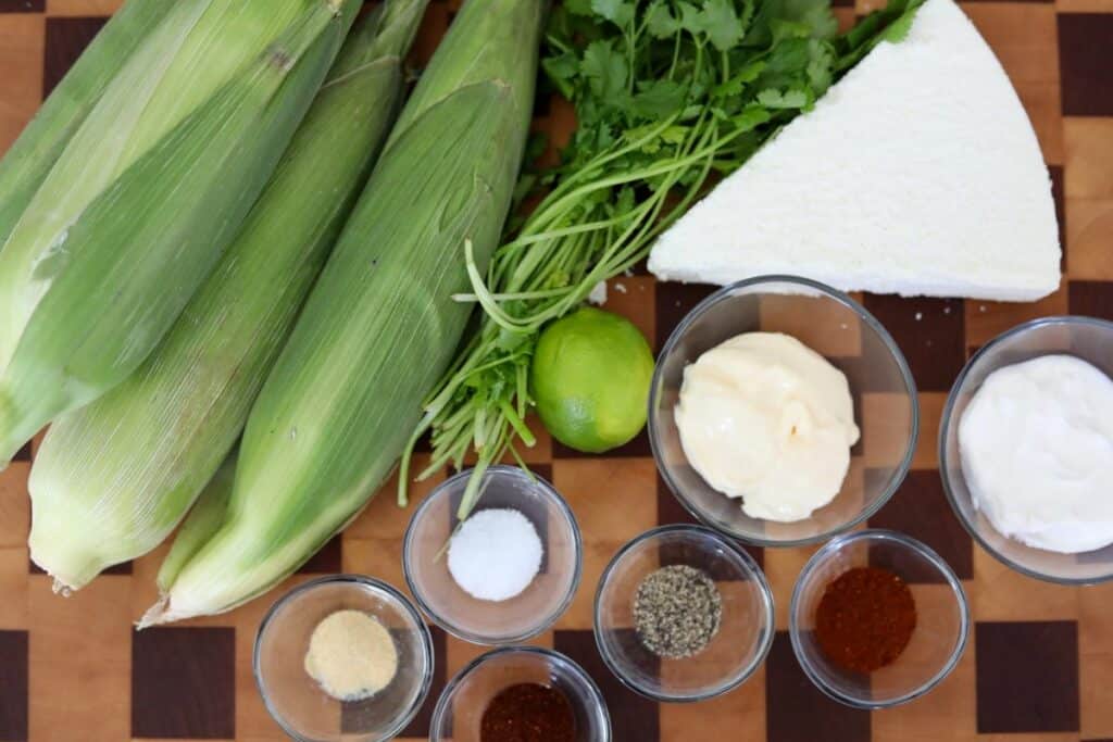 Ingredients for street corn on a wooden cutting board