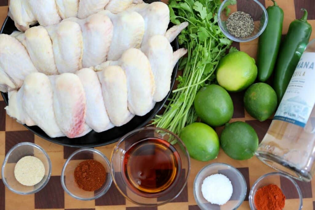 Ingredients for tequila lime chicken wings on a wooden cutting board