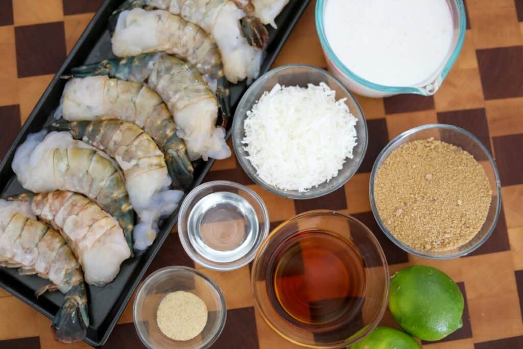 Ingredients for coconut and rum shrimp on a wooden cutting board