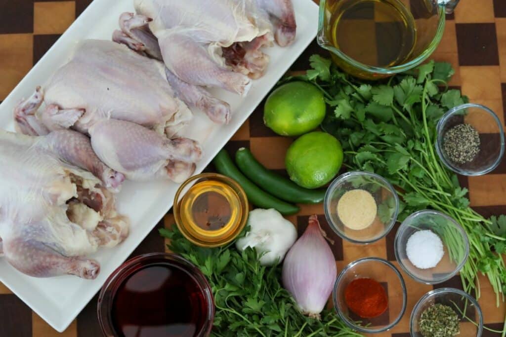 Ingredients for grilled Cornish hens on a wooden cutting board