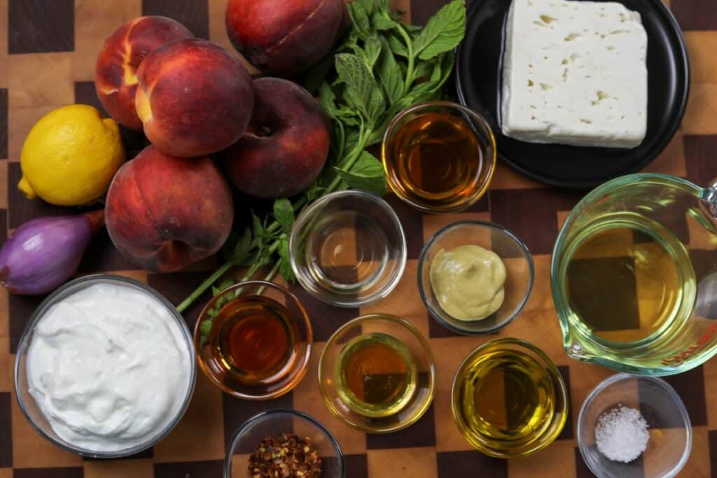 Ingredients for grilled peach salad on a wooden cutting board