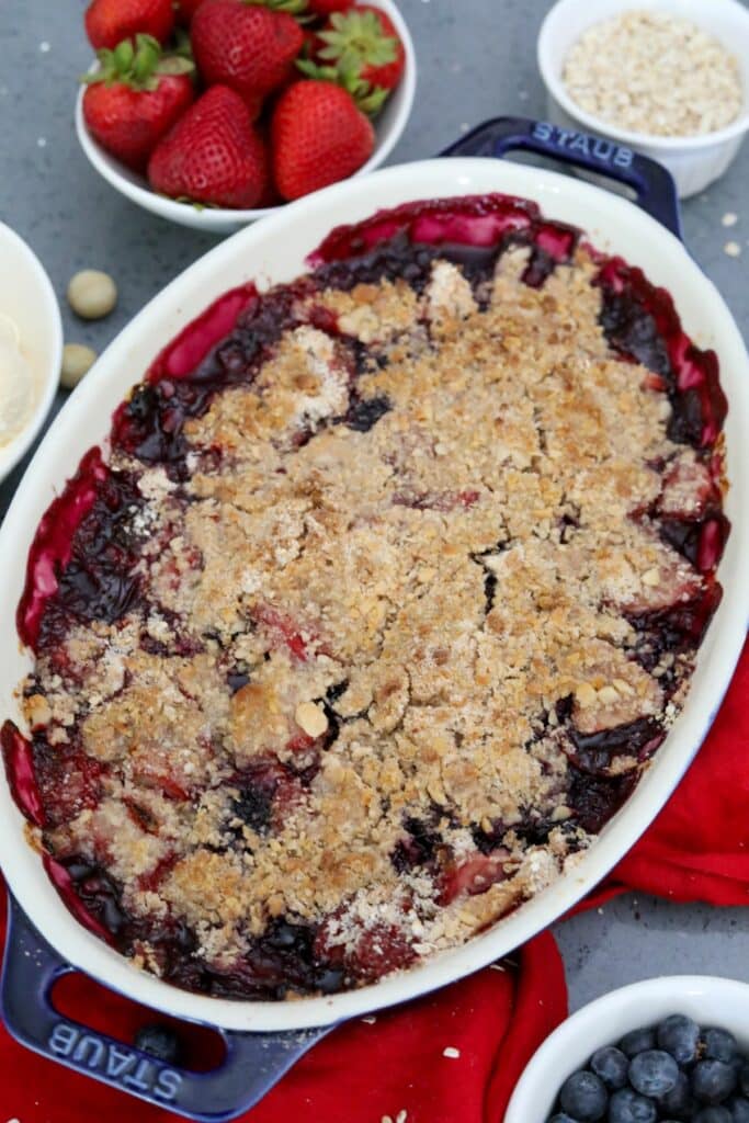 Baked strawberry and blueberry crisp in a blue dish