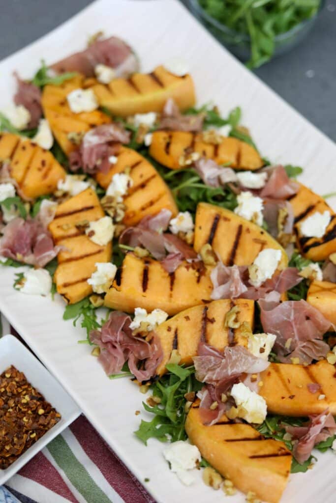 grilled cantaloupe salad on a white platter