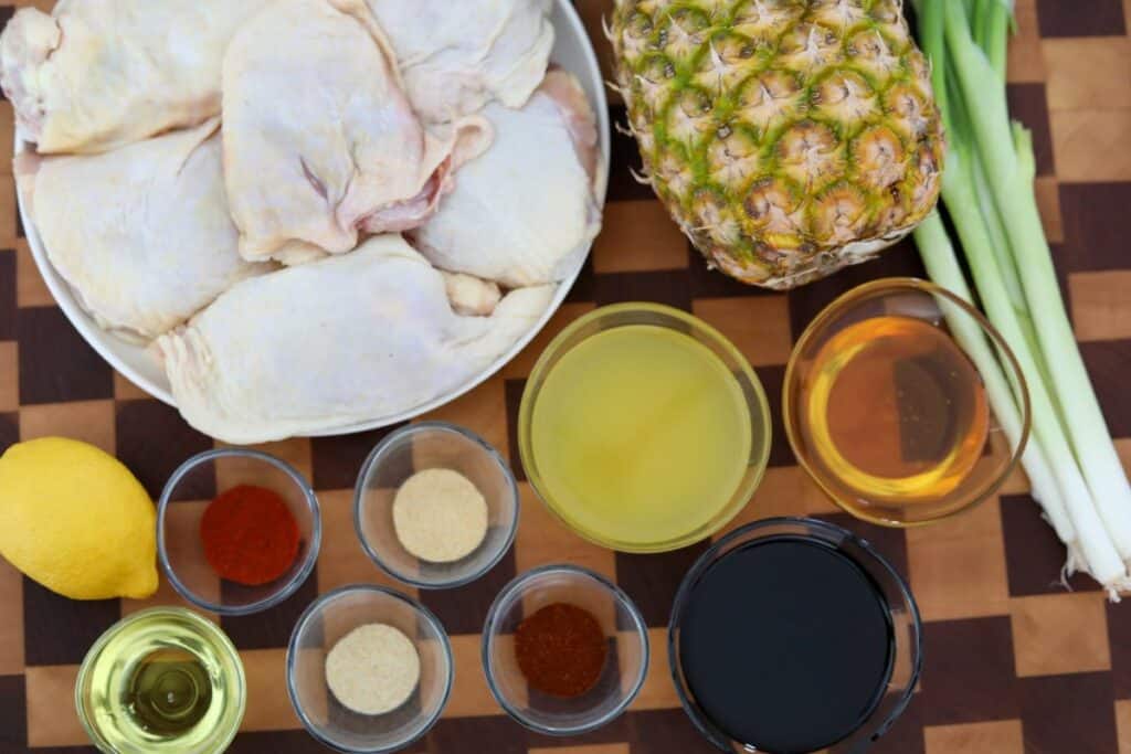 Ingredients for pineapple chicken on a wooden cutting board