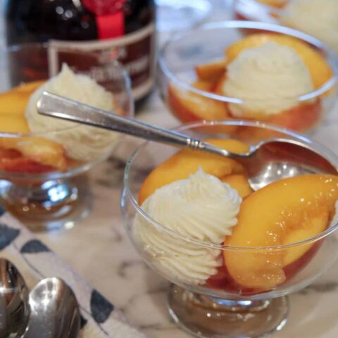 Dessert dishes with prosecco peaches with a spoon in it