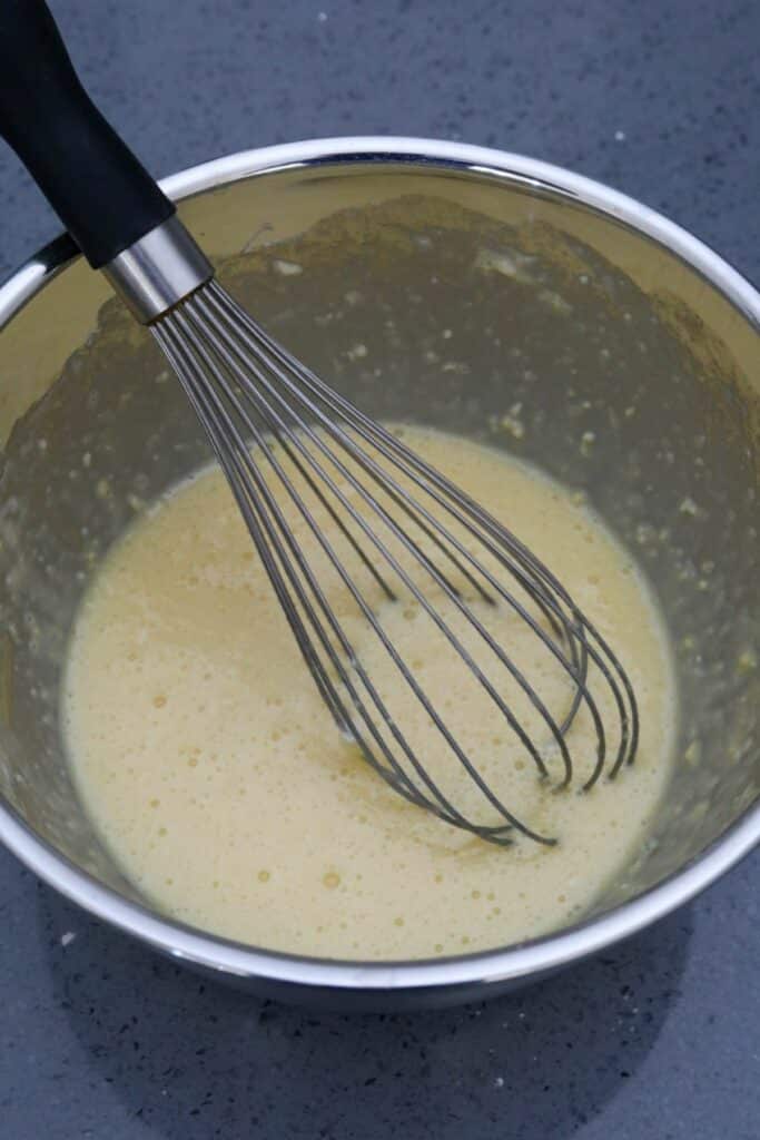 Egg and flour mixture in a mixing bowl with whisk