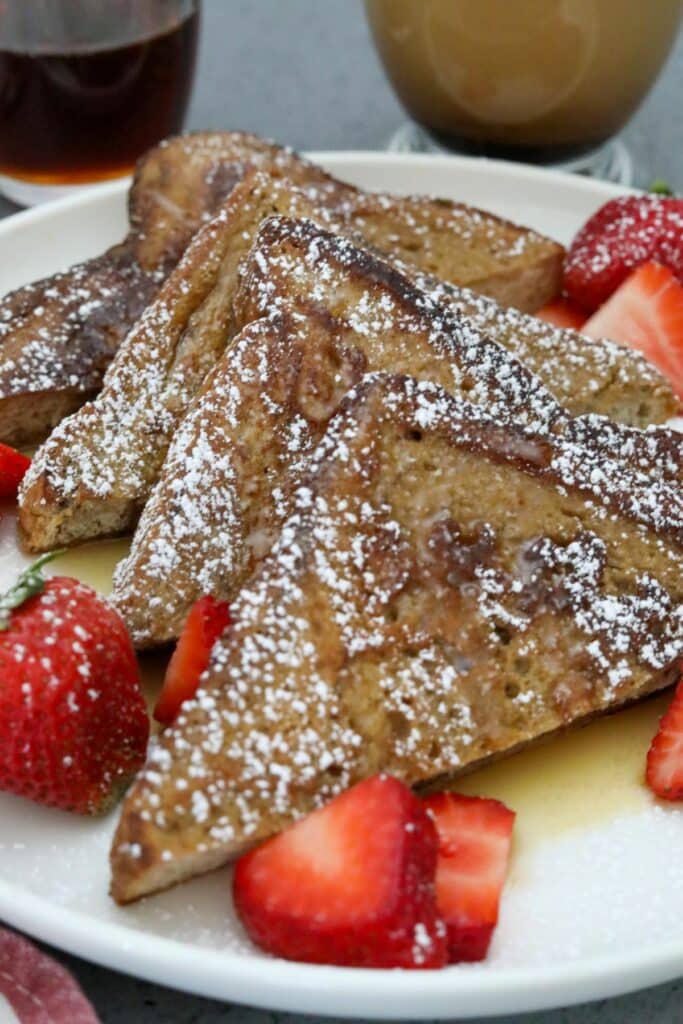 Sliced French toast with syrup and strawberries.