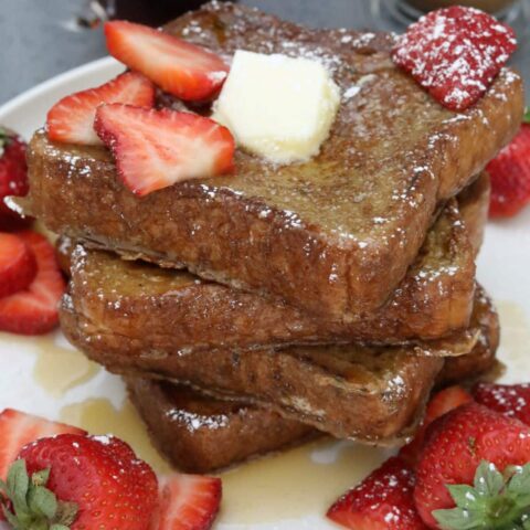 A stack of French toast with syrup and butter