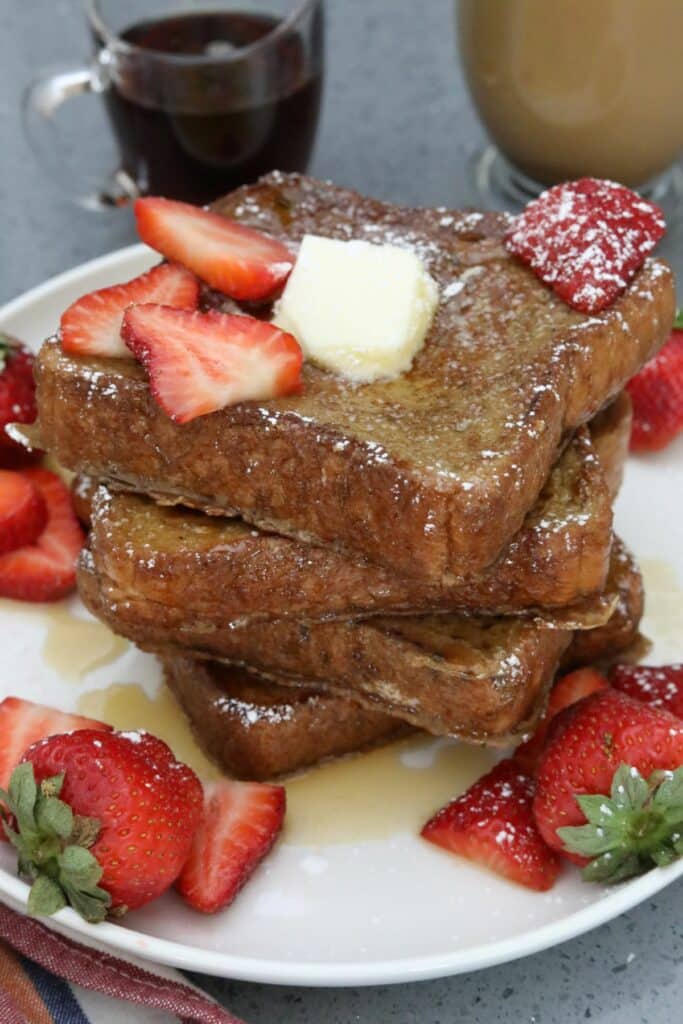 A stack of French toast with syrup and butter