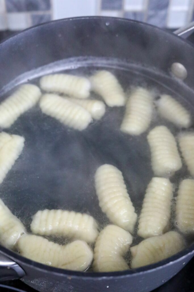 Gnocchi floating in a pot of water