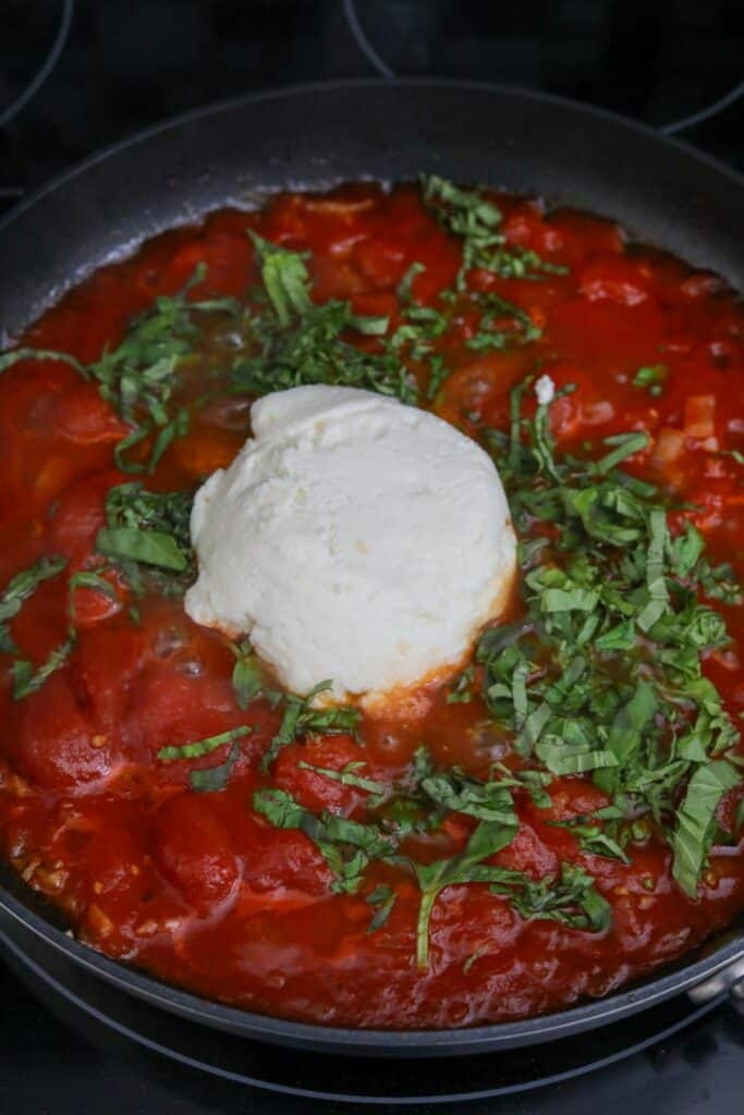 Basil and ricotta added to tomatoes