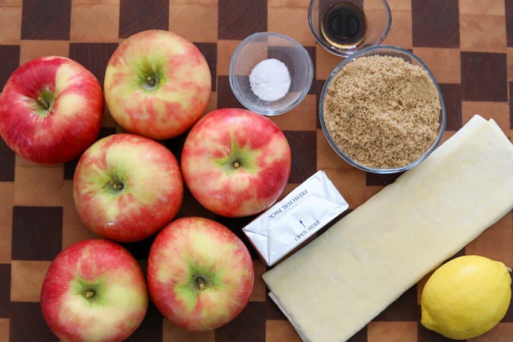 Ingredients for apple tarte tatin on a wooden cutting board