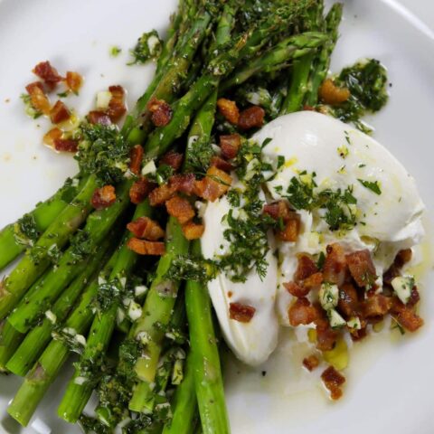 A plate with Asparagus with burrata and pancetta