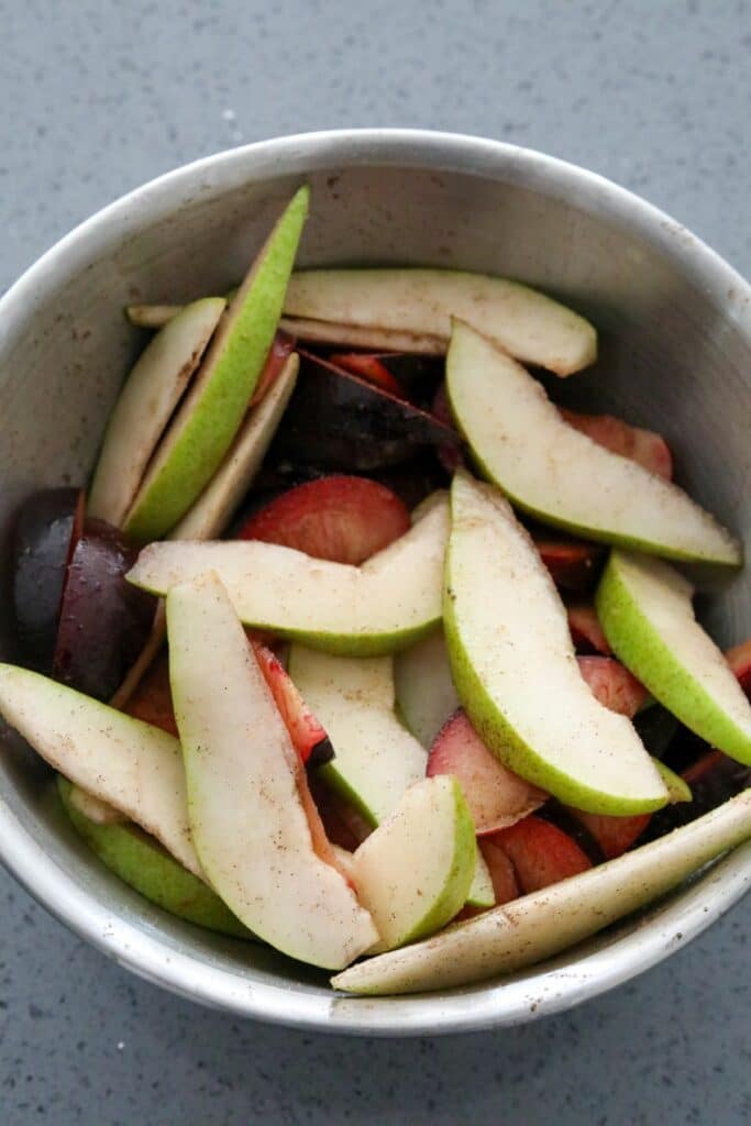 Seasoned pears and plums in a bowl