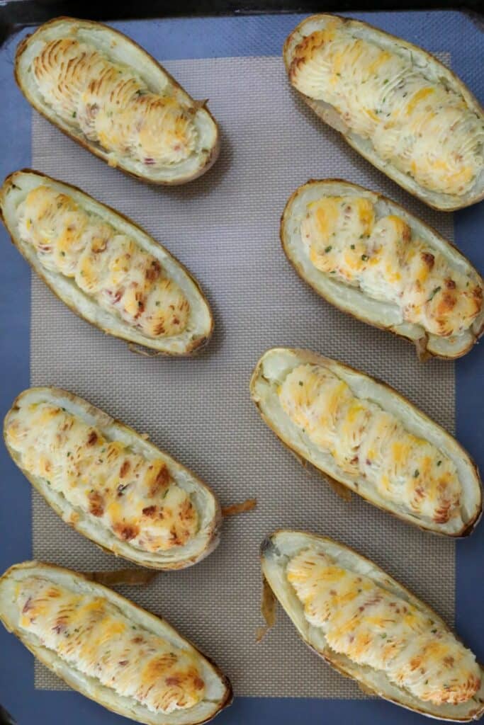 Cooked twice baked potatoes on a lined sheet pan