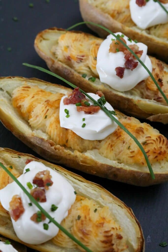 Close up of 4 twice baked potatoes on a slate plate