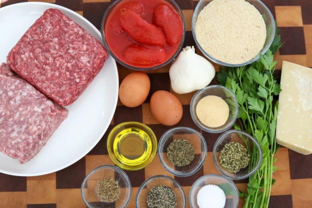 Ingredients for Italian meatballs on a wooden cutting board