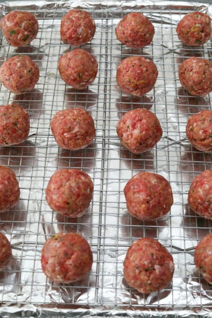 Uncooked meatballs on a baking rack