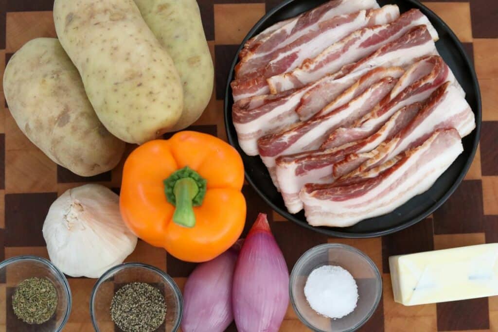 Ingredients for bacon potato hash on a wooden cutting board