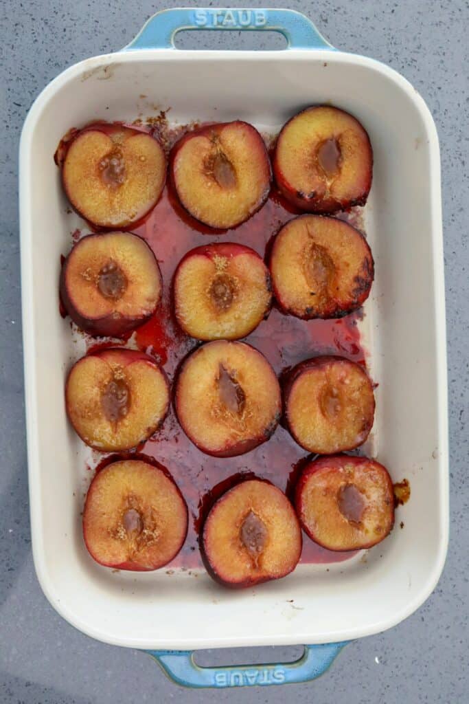 Baked plums in a teal baking dish