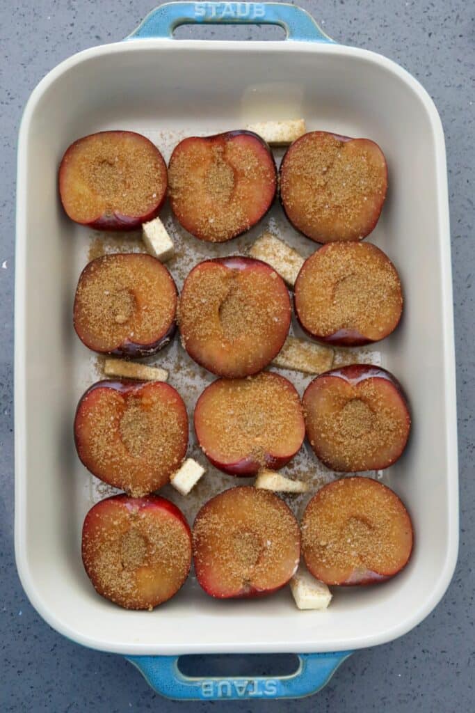 Plums topped with brown sugar mixture in a baking dish