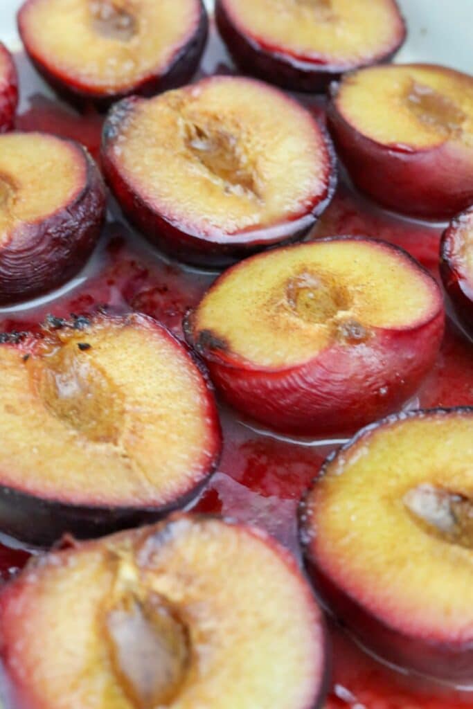 Close up of baked plums in a baking dish