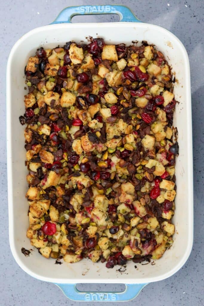 A baking dish with cooked cranberry and pistachio dressing