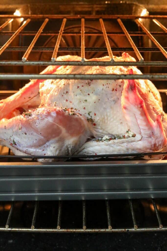A turkey in a roasting pan in the oven