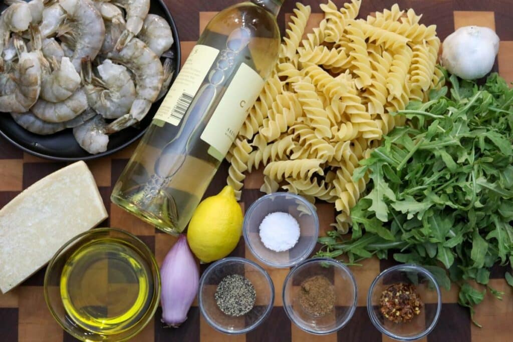 Ingredients for shrimp fusilli on a wooden cutting board