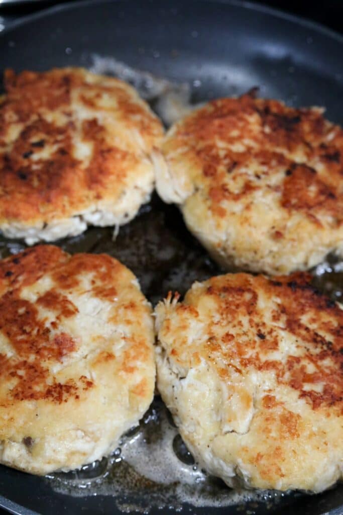 Four cooked turkey patties in a skillet