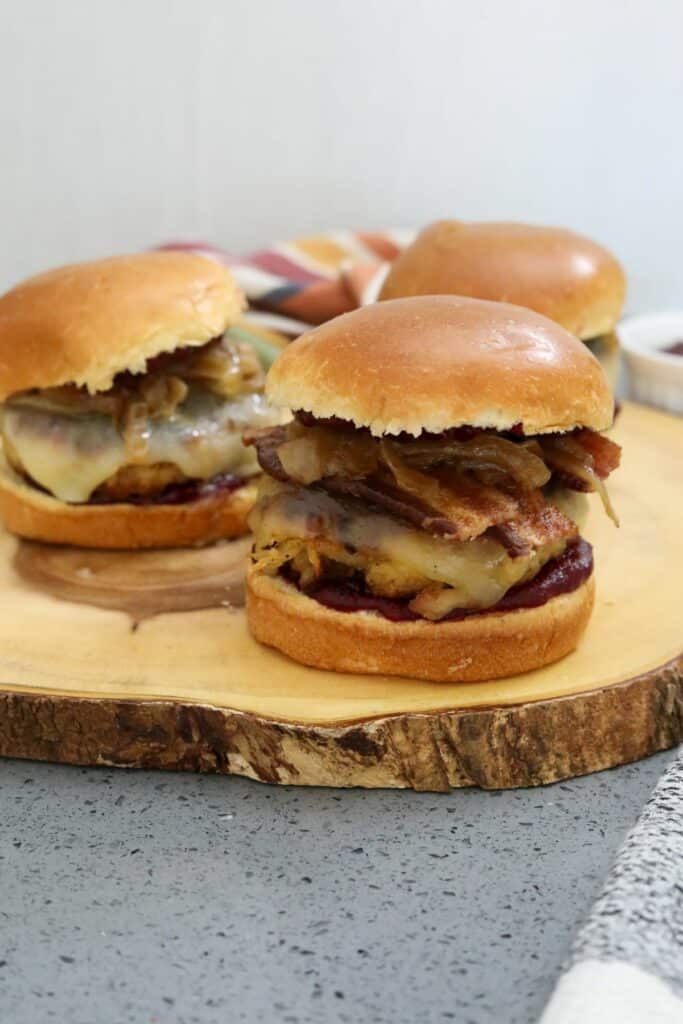 Three turkey burgers on a wood platter