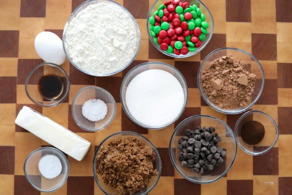 Ingredients for Chocolate Chip M&M Cookies on a wooden cutting board