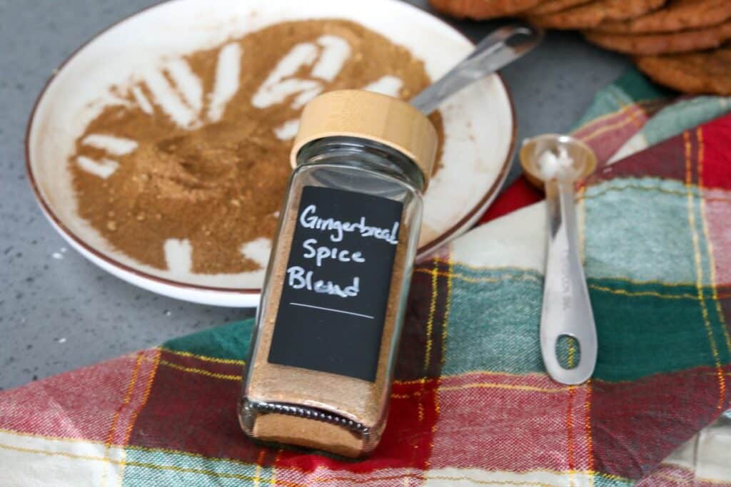 gingerbread spice blend in a spice jar resting on a plate