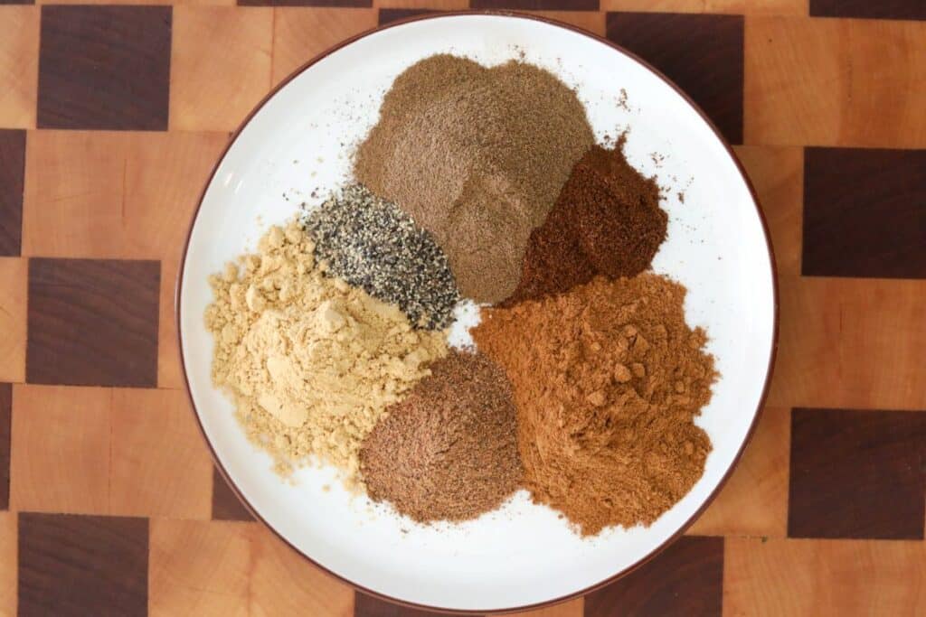 Ingredients for gingerbread spice blend on a white plate