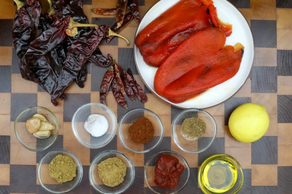 Ingredients for harissa on a wooden cutting board