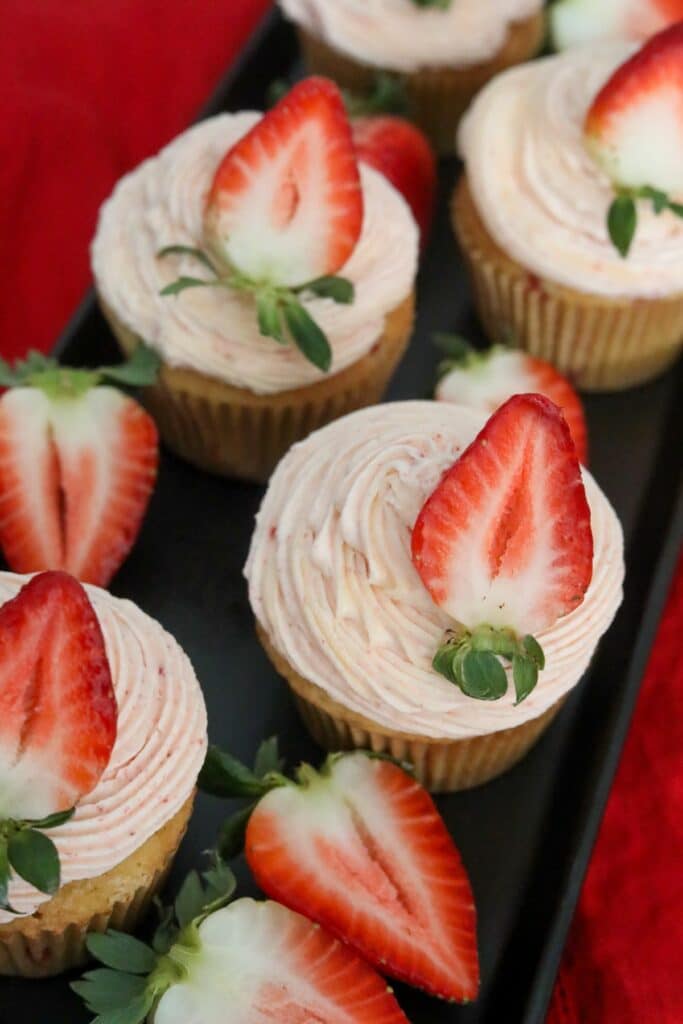 Close up of strawberry cupcakes on a black platter