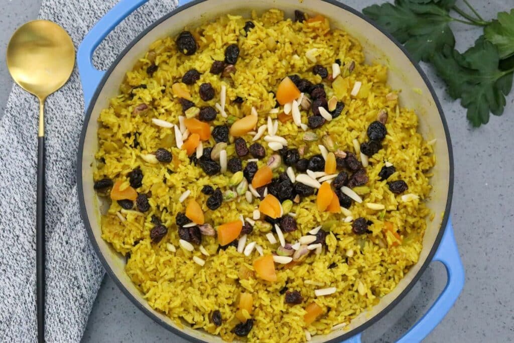 Casserole dish with Moroccan rice pilaf with a serving spoon