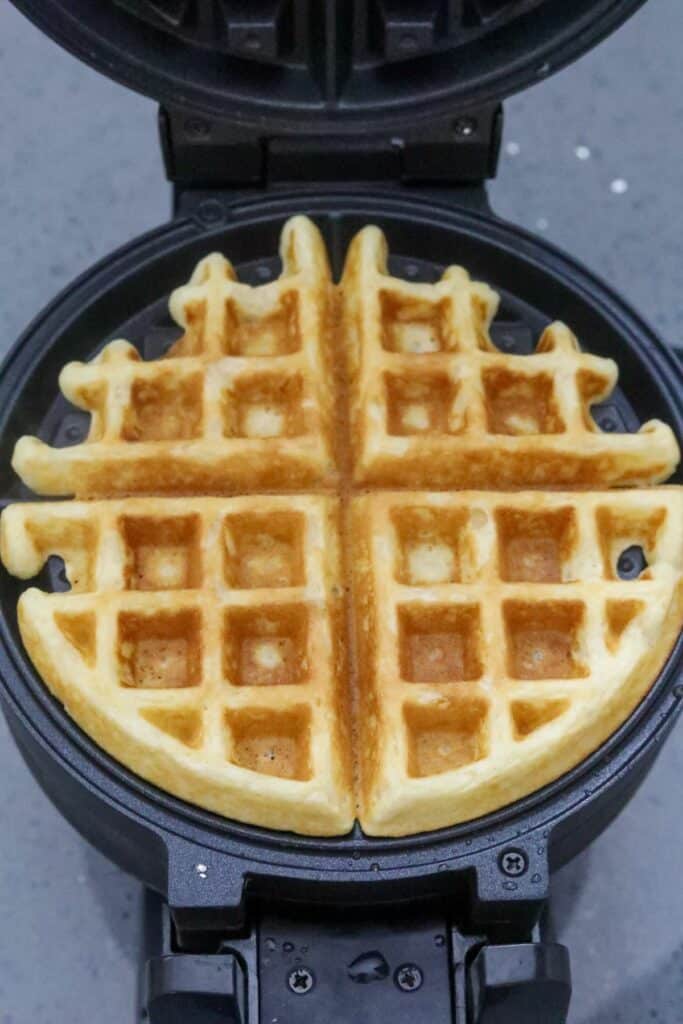 A cooked Belgian waffle in a waffle iron