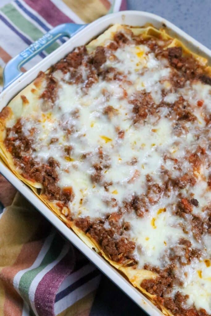 Cooked lasagna Bolognese in a blue casserole dish