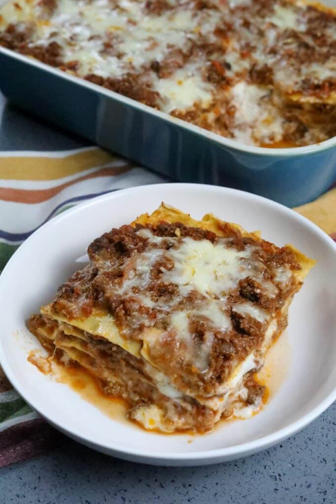 A white bowl with a slice of lasagna Bolognese